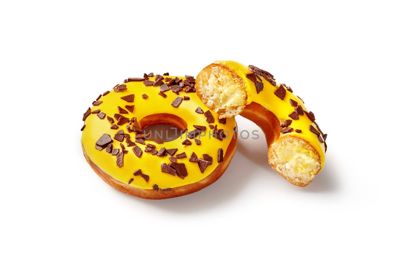 Appetizing fluffy donuts with tropic taste, filled with mango and passion fruit flavored buttercream, topped with vibrant yellow icing isolated on white background