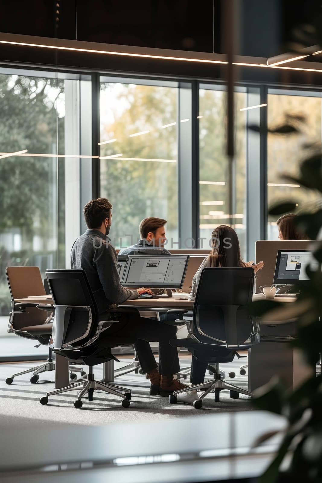 This image shows a team of diverse professionals collaborating at a spacious open-plan office with a city view. The setting is vibrant and dynamic, reflecting a modern, collaborative work culture.