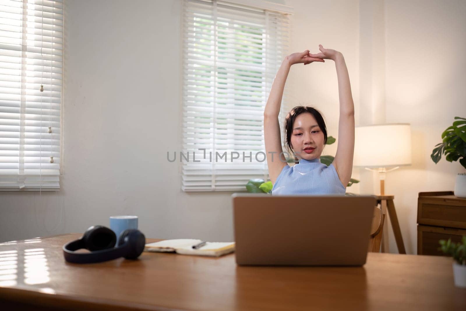 Asian young student doing stretch oneself from study online class. Online distance learning education concept.