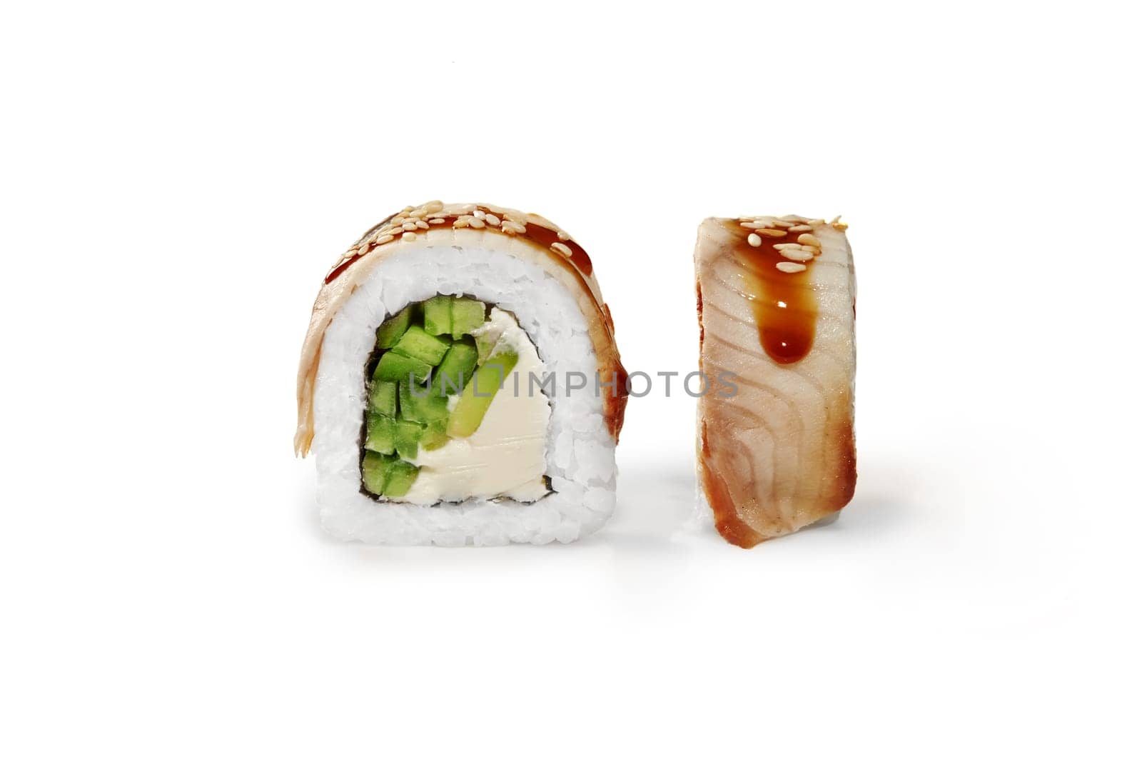 Delicious Philadelphia eel sushi roll filled with soft cream cheese, cucumber and avocado drizzled with sweetish tangy unagi sauce and sesame, isolated on white background. Popular Japanese dish
