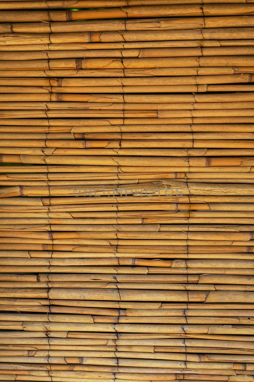 Close-up of a stacked bamboo mat, highlighting natural patterns and warm tones. by sfinks