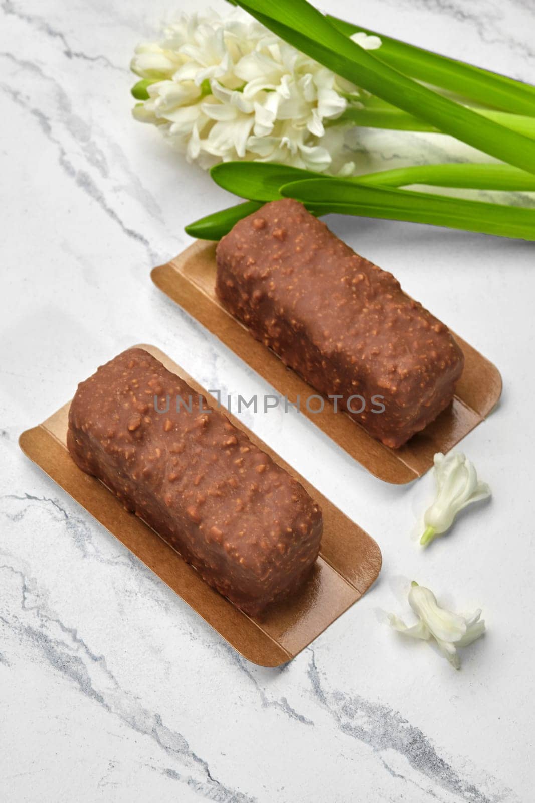Artisan chocolate nut loaf cakes, perfect combination of texture and taste, presented on marble backdrop with delicate white hyacinth