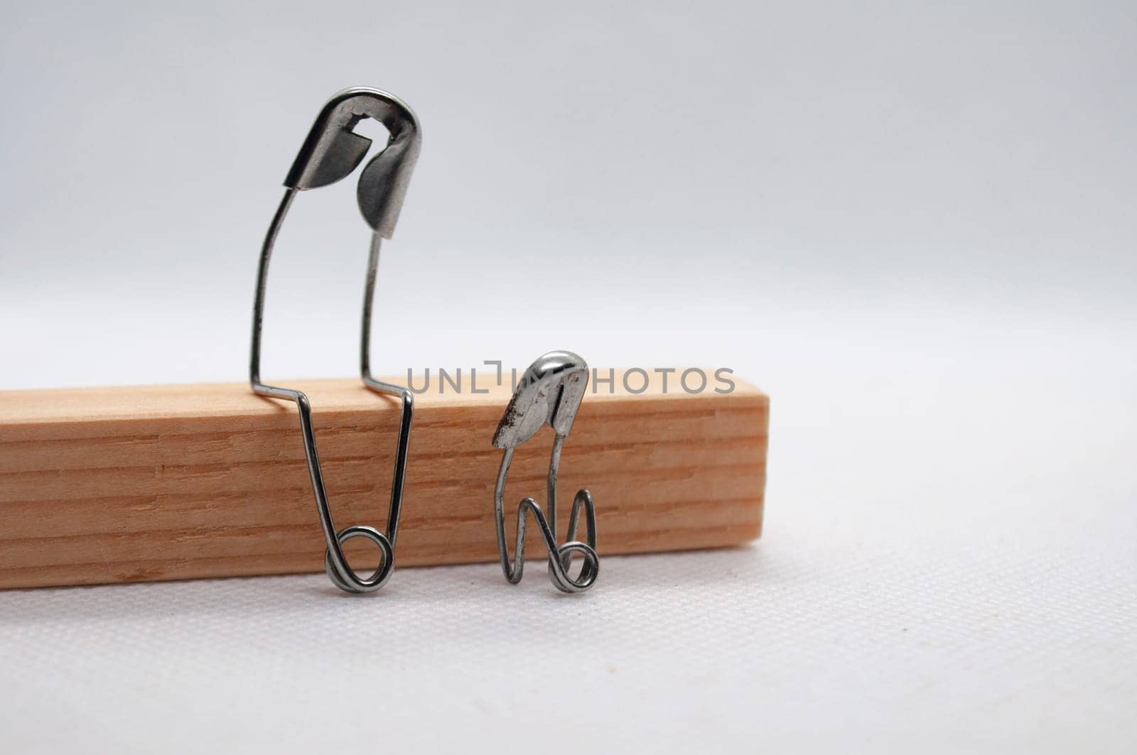 Model safety pin of mother or farther comforting his of her son. Family concept.