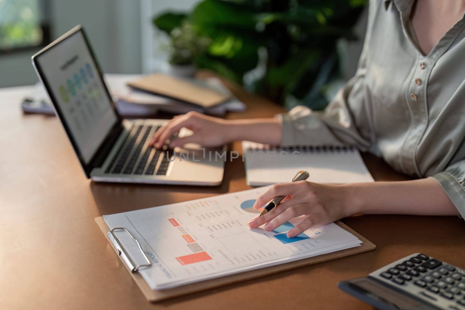 Businesswoman using laptop computer and working at office with calculator document on desk, doing planning analyzing the financial report, business plan investment, finance analysis concept by nateemee