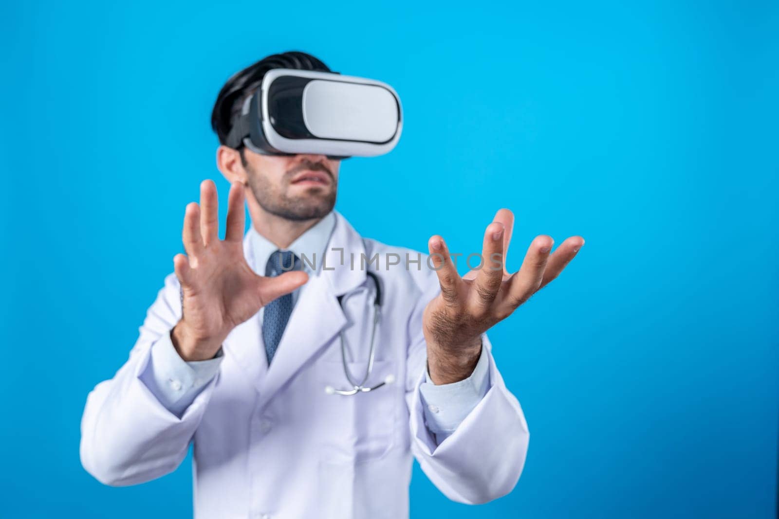 Smart doctor looking VR glass and standing with blue background. Caucasian doctor holding and checking medical data while wearing virtual reality world or metaworld. Innovation technology. Deviation.