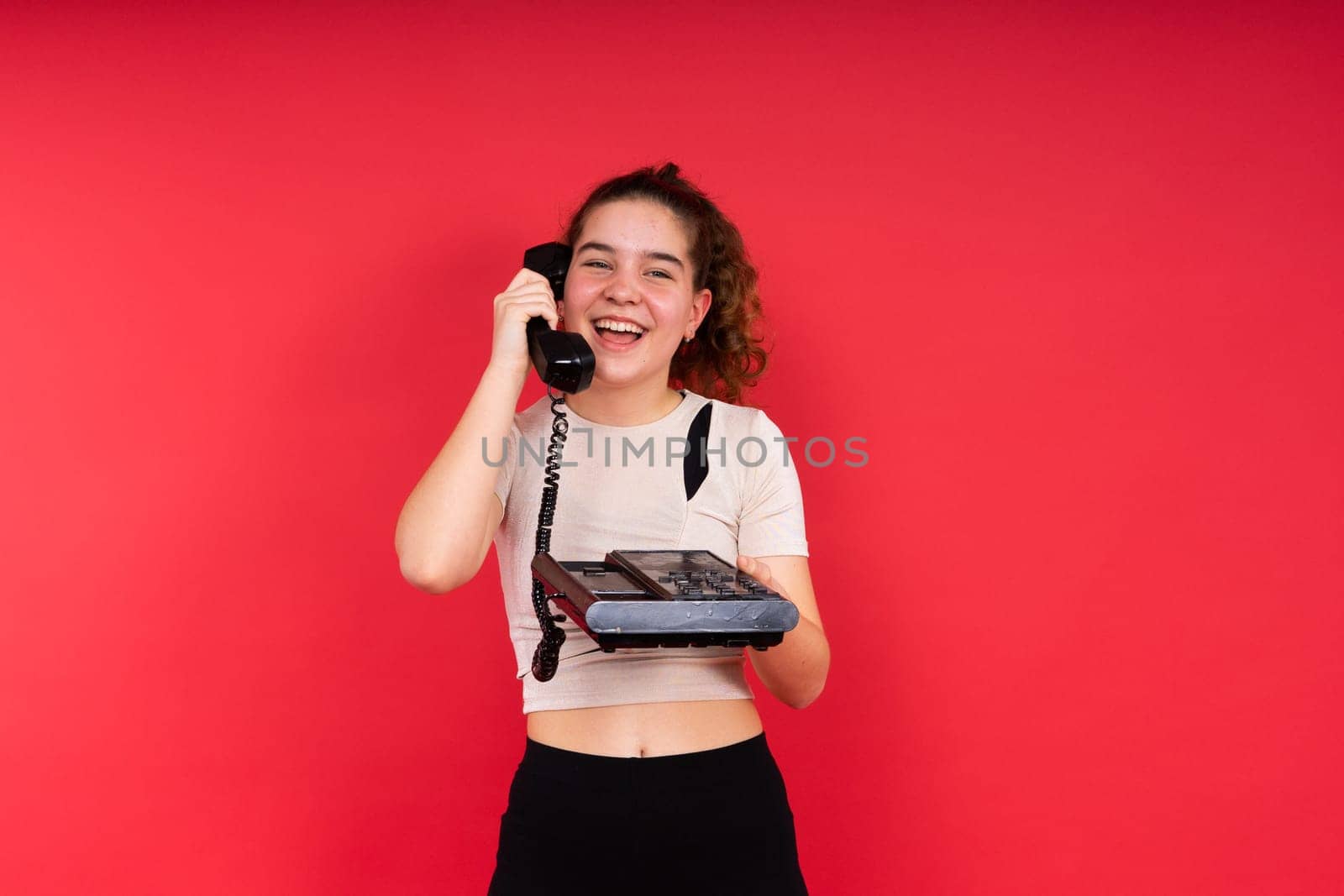 Portrait of pretty person arms hold vintage handset doubtful face isolated on red color background by Zelenin