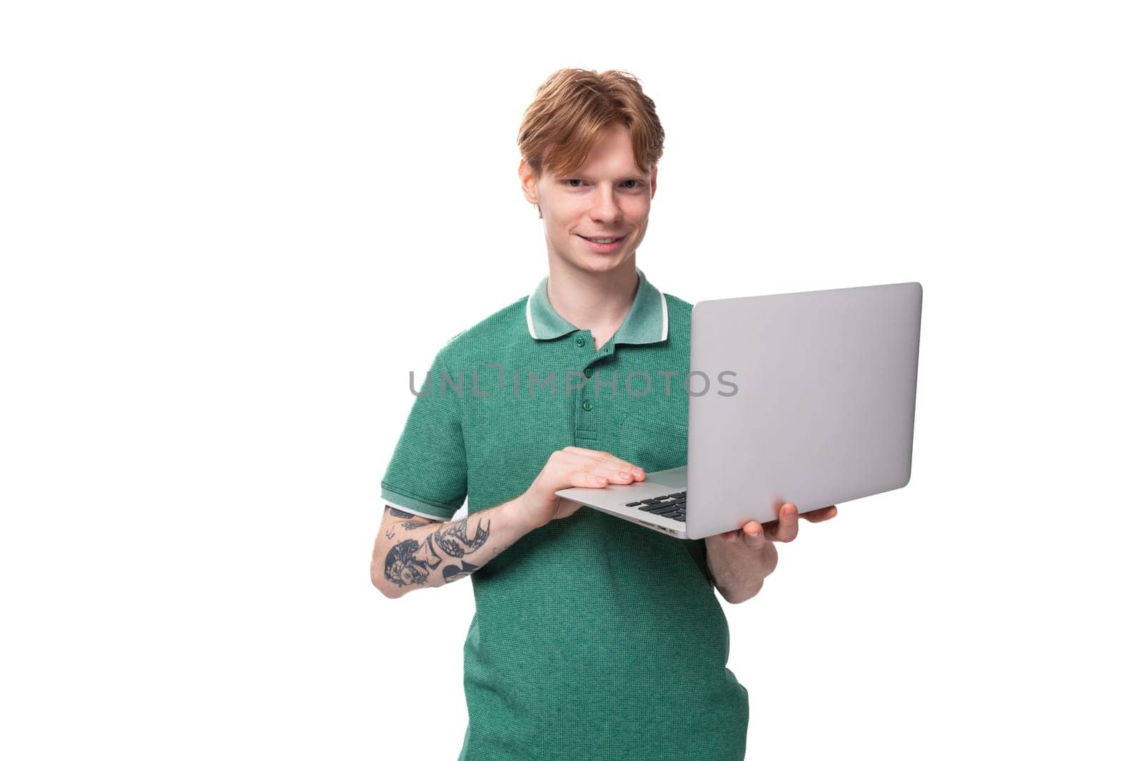 young smart successful student european man with red hair holding a laptop.