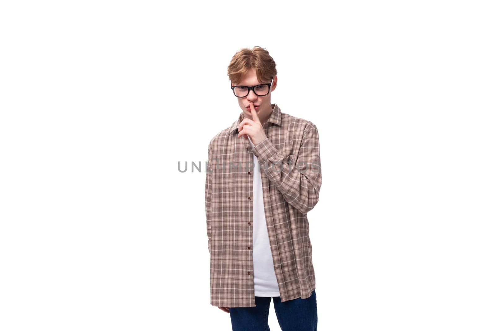 a young European man with red hair in glasses and a plaid shirt thought. people lifestyle concept.