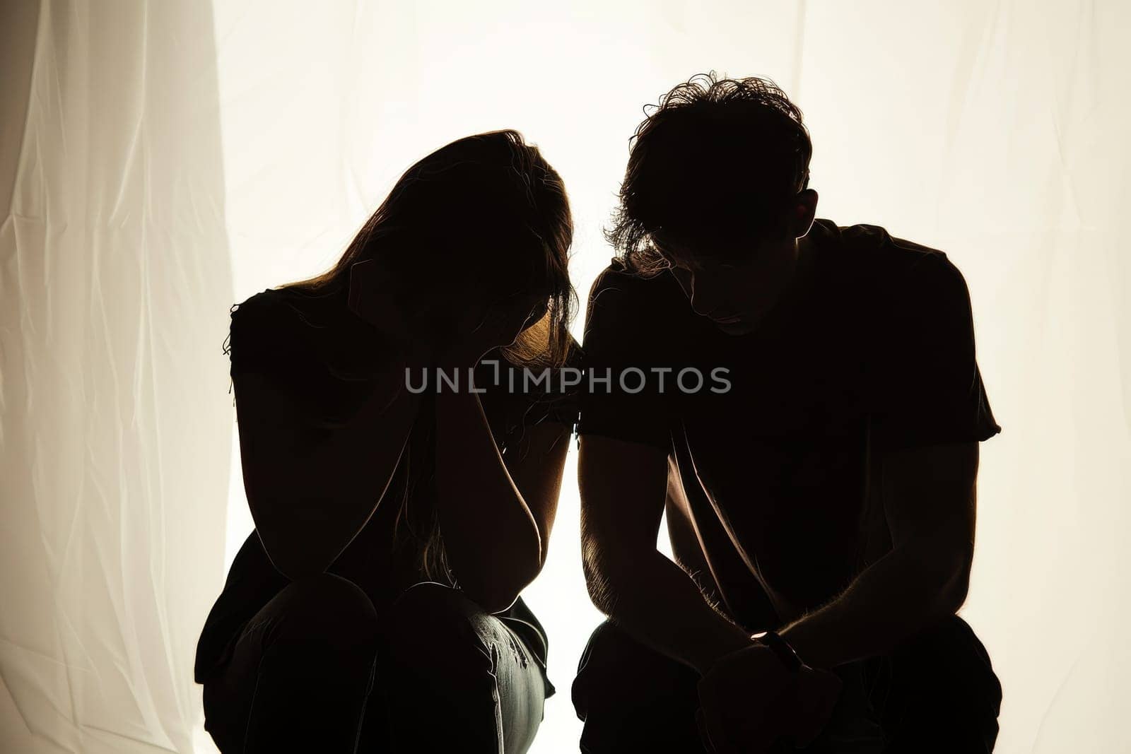 Two people are sitting on the floor, crying. Scene is sad and emotional