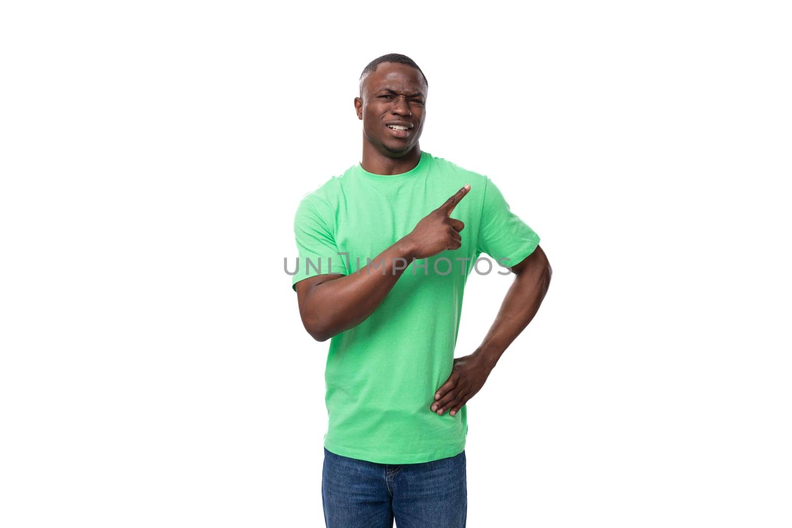 handsome positive inspired 30 year old american man wearing light green basic t-shirt points finger.