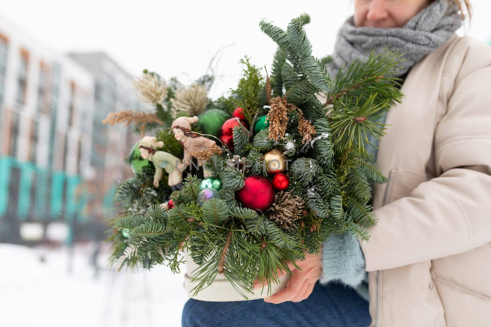 Woman Holding a Bouquet of Christmas Decorations by TRMK