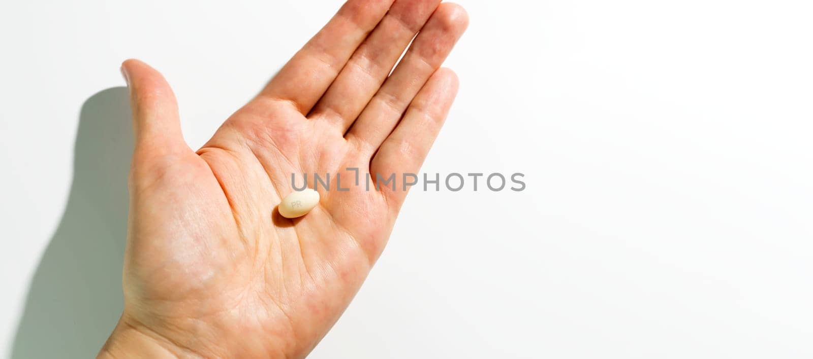Design Progesterone Pill, Capsules In Human Hand On White Background. Dose Of Medications Treats Irregular Menstrual Cycle, Fertility Treatments, Menopausal Hormone Therapy, Horizontal Copy Space by netatsi