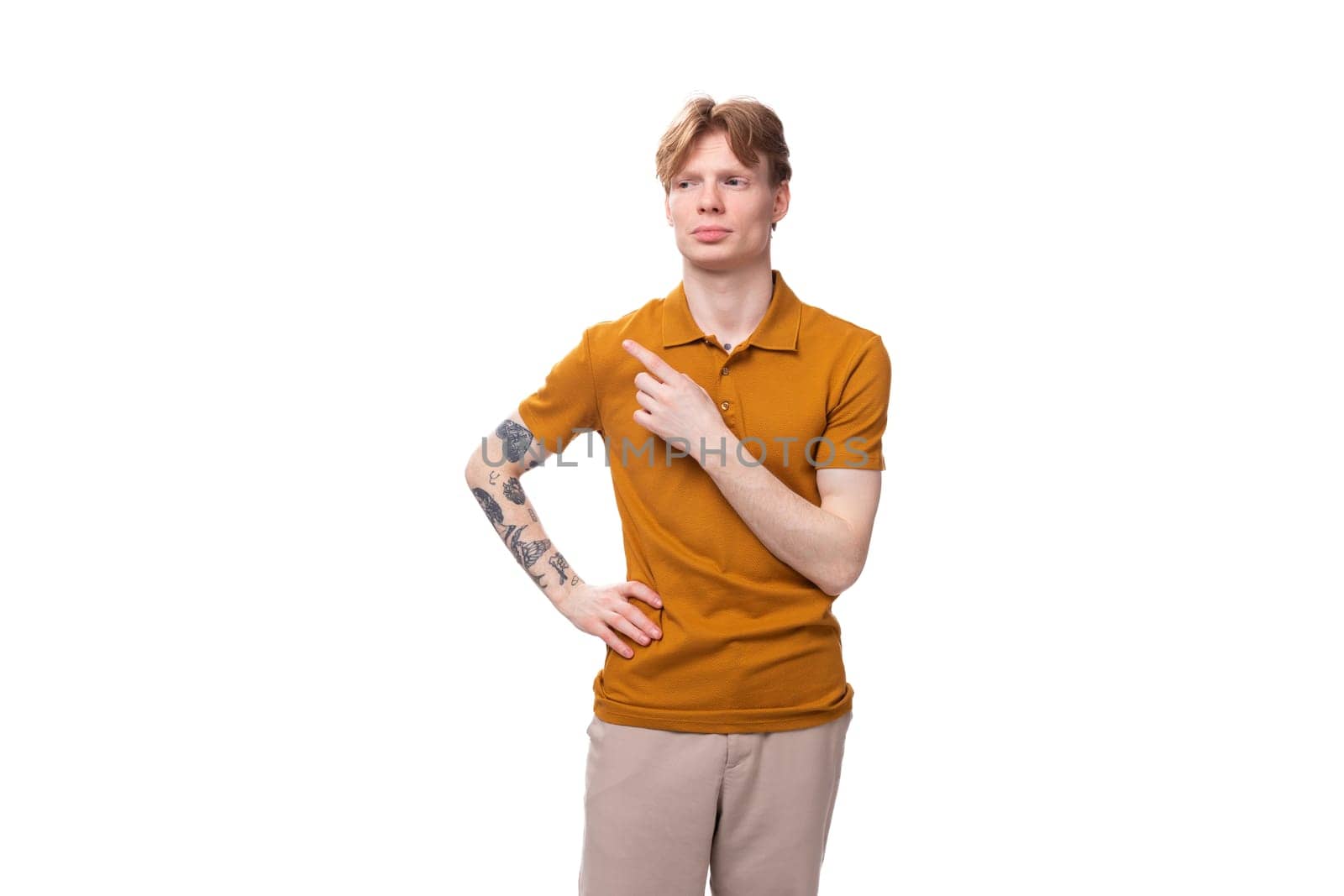 young red-haired guy in a yellow t-shirt points with his hand by TRMK