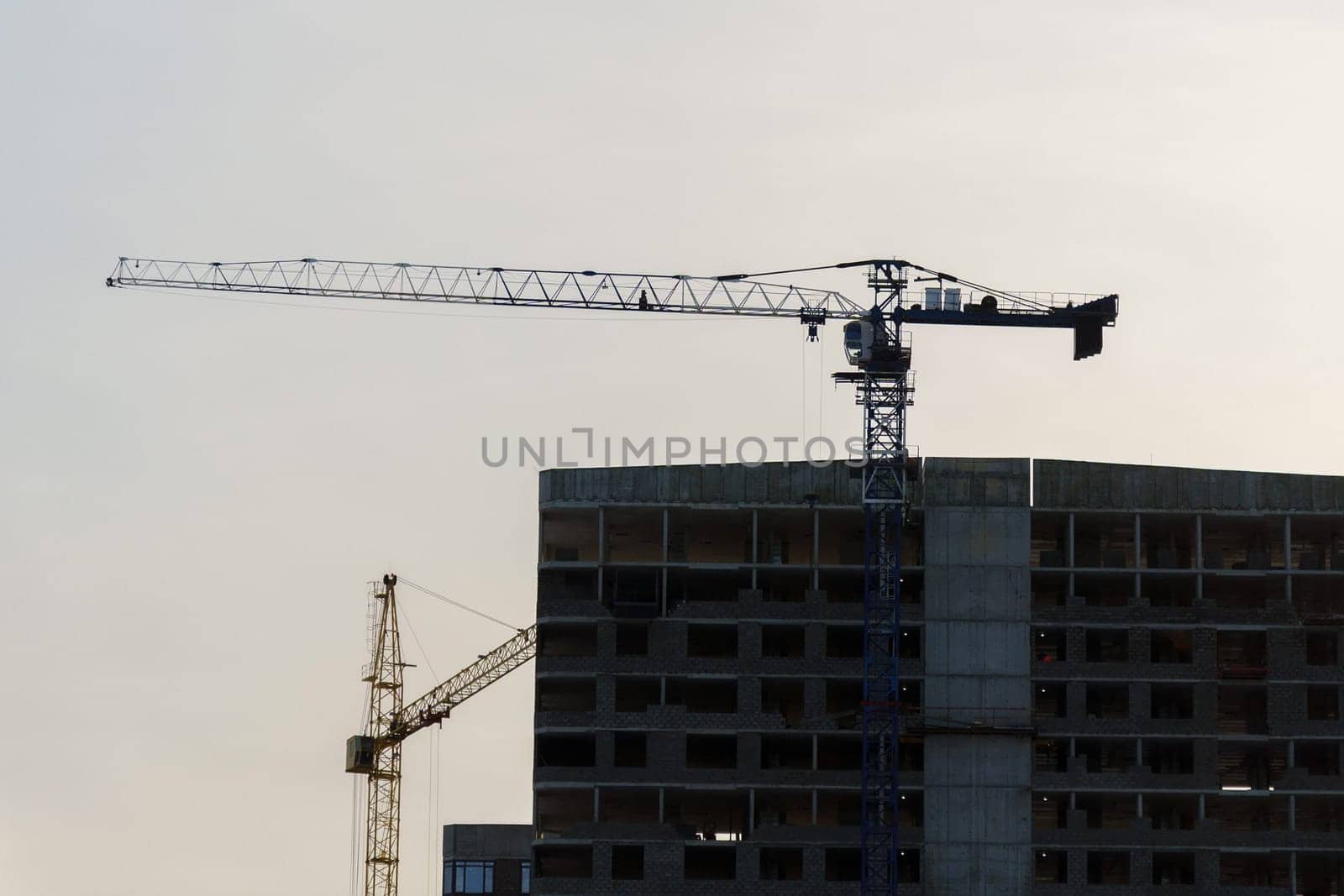 Construction crane at a construction site. Construction of new houses