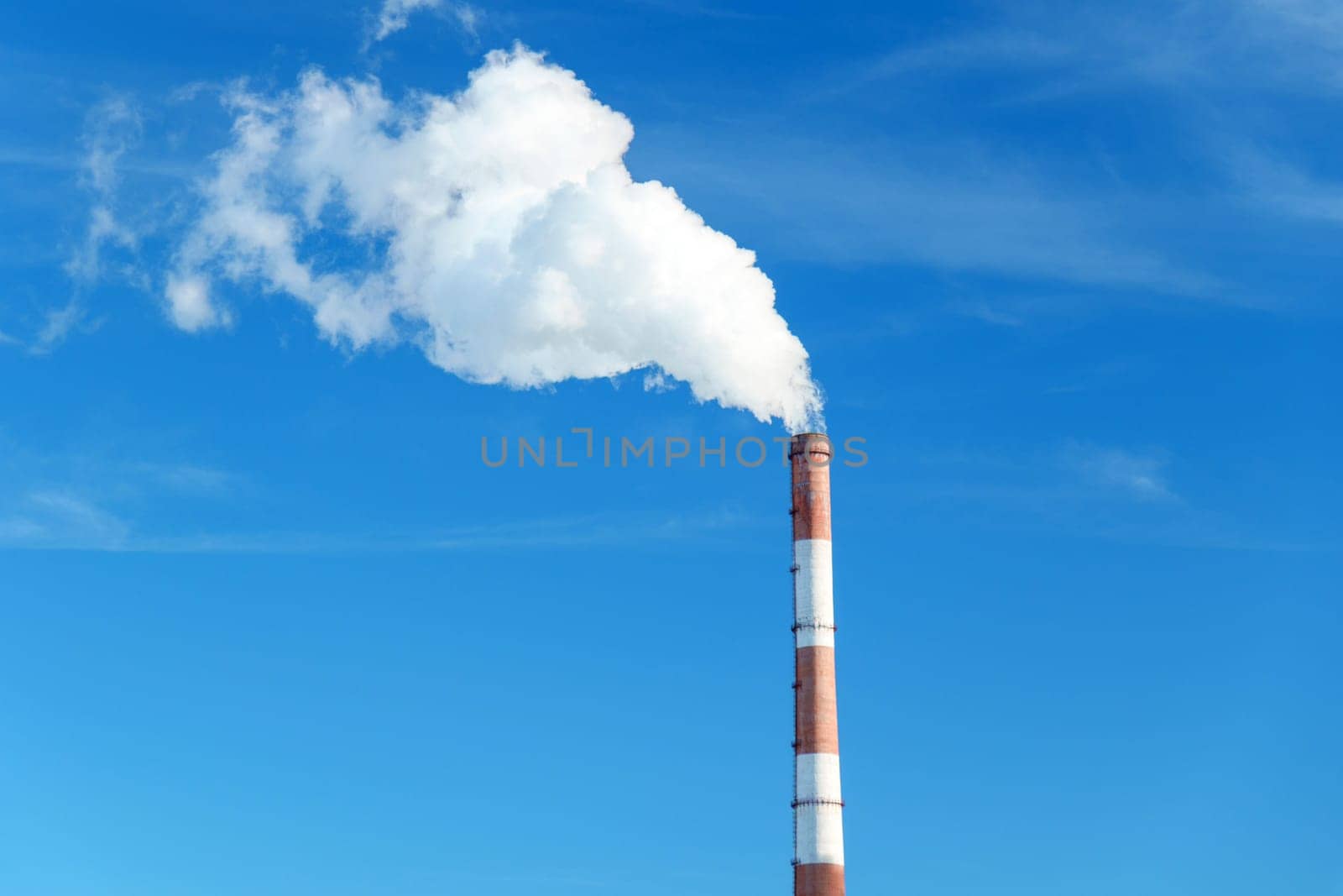 Smokestack emits thick smoke from a pipe, contrasting against a clear blue sky by darksoul72
