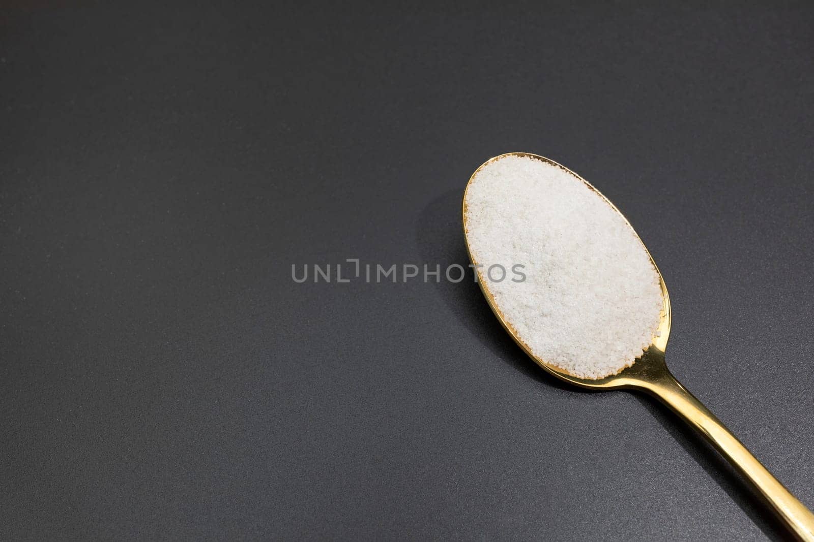 Design Celtic Gray Sea Salt In Golden Spoon on Dark Table, Copy Space. Horizontal Plane. Natural And Unrefined Salt Harvested From Brittany, France. Natural Minerals And Trace Elements, Superfood by netatsi