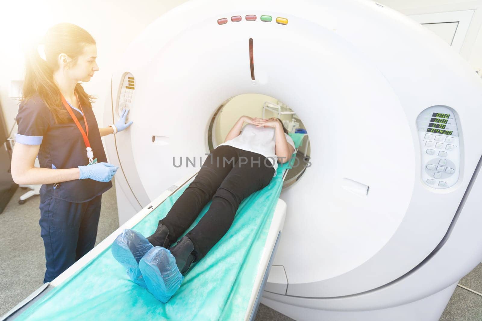 Radiologist with a female patient in the room of computed tomography