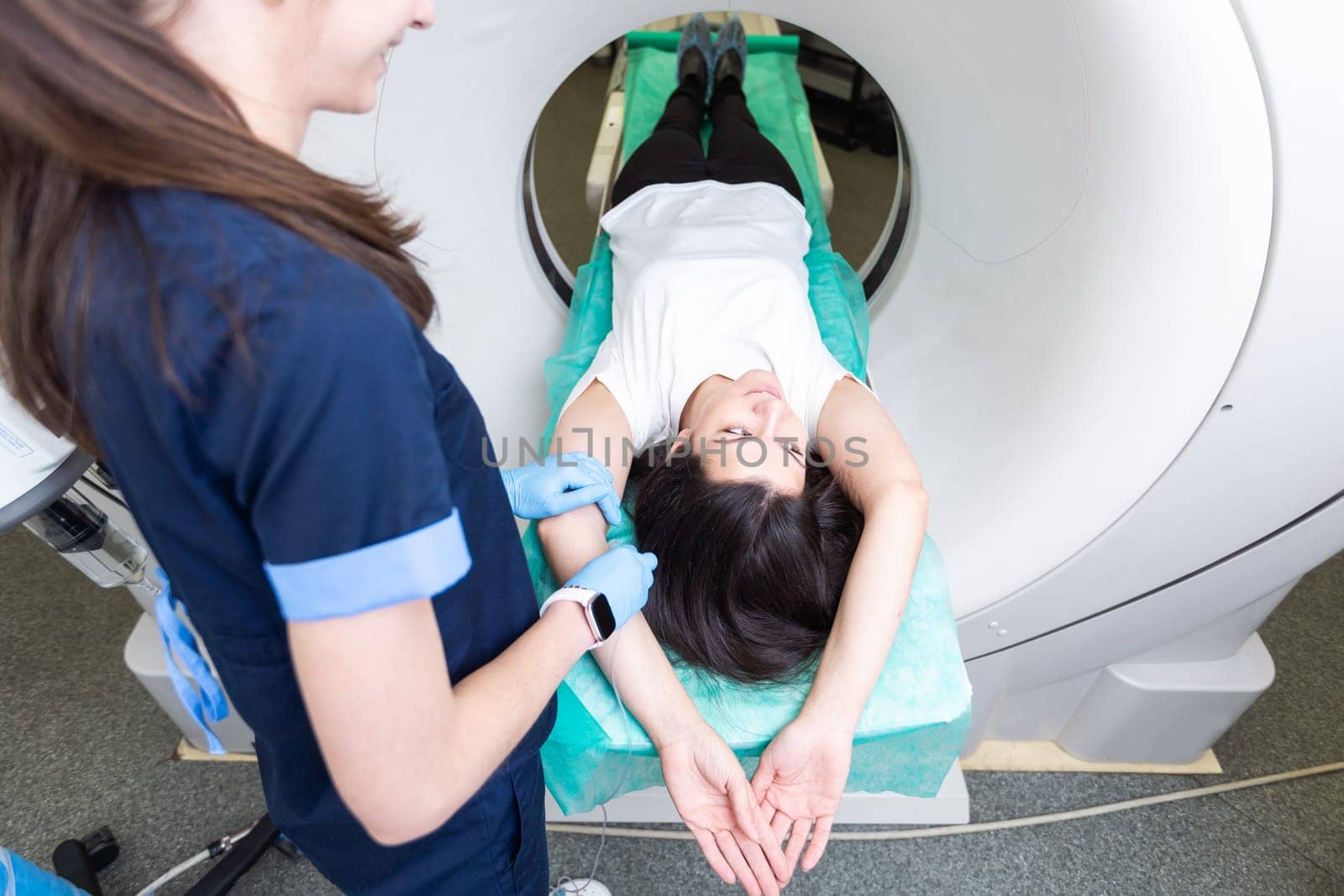 Pretty, young woman goiing through a Computerized Axial Tomography CAT Scan medical test examination in a modern hospital.