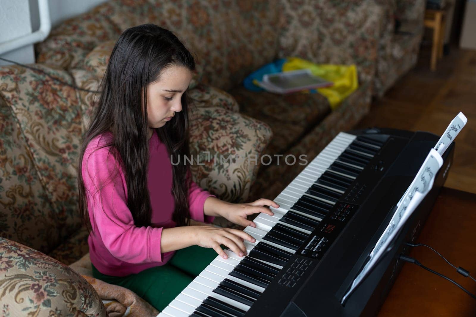 Portrait of little sad girl in ruined building. little settler plays the piano. Refugees by Andelov13