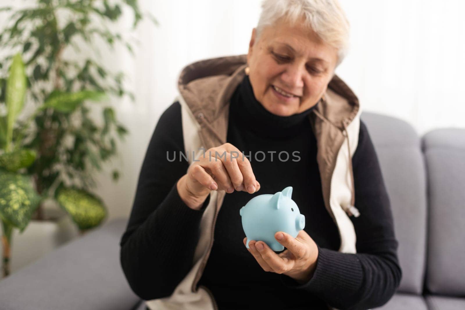 Senior woman holding piggy bank.