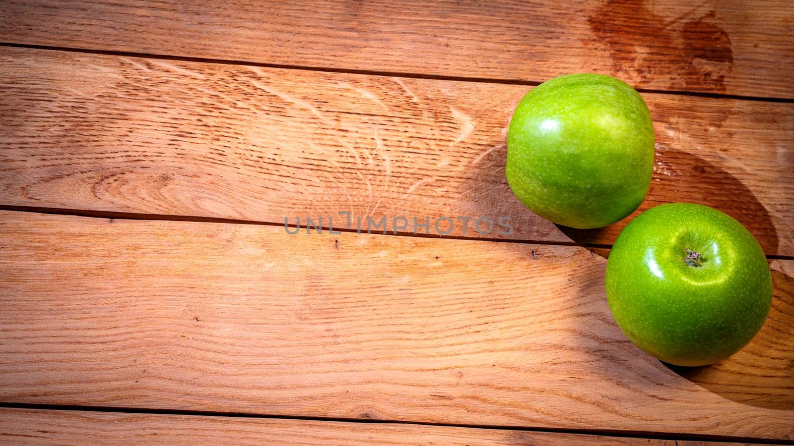 Detail on ripe green apples on wooden table.