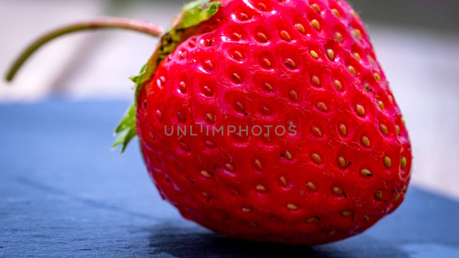 Close up of fresh strawberry showing seeds achenes. Details of a fresh ripe red strawberry. by vladispas