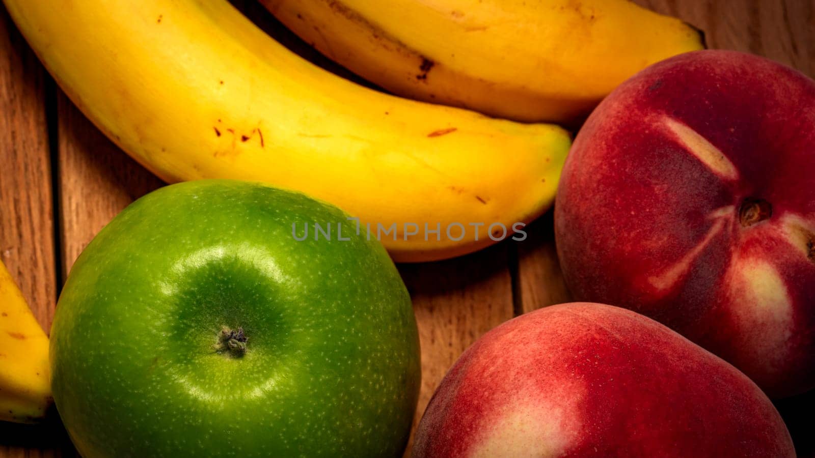 Apple, peach and bananas on a wooden board. Composition of healty fruits.