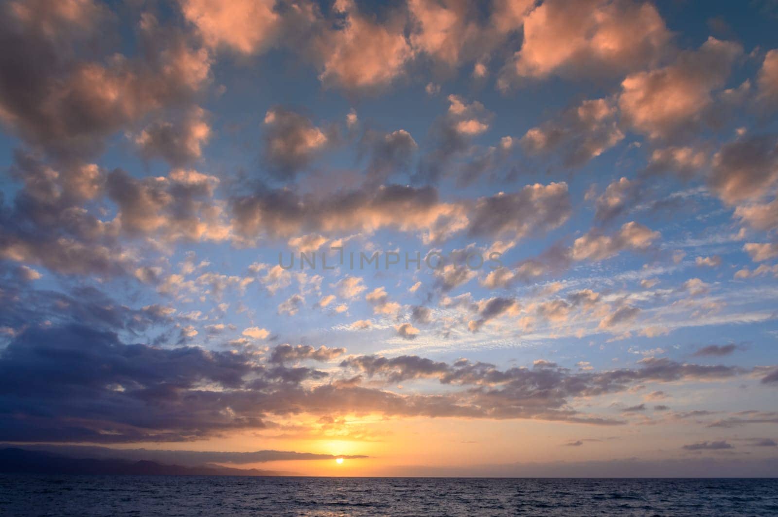 beautiful clouds over the Mediterranean sea in the rays of sunset