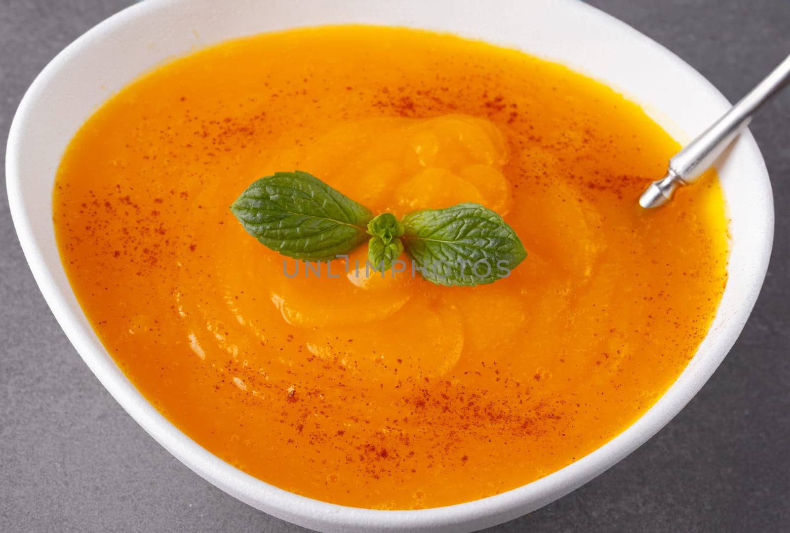 Pumpkin soup on grey background by NataliPopova
