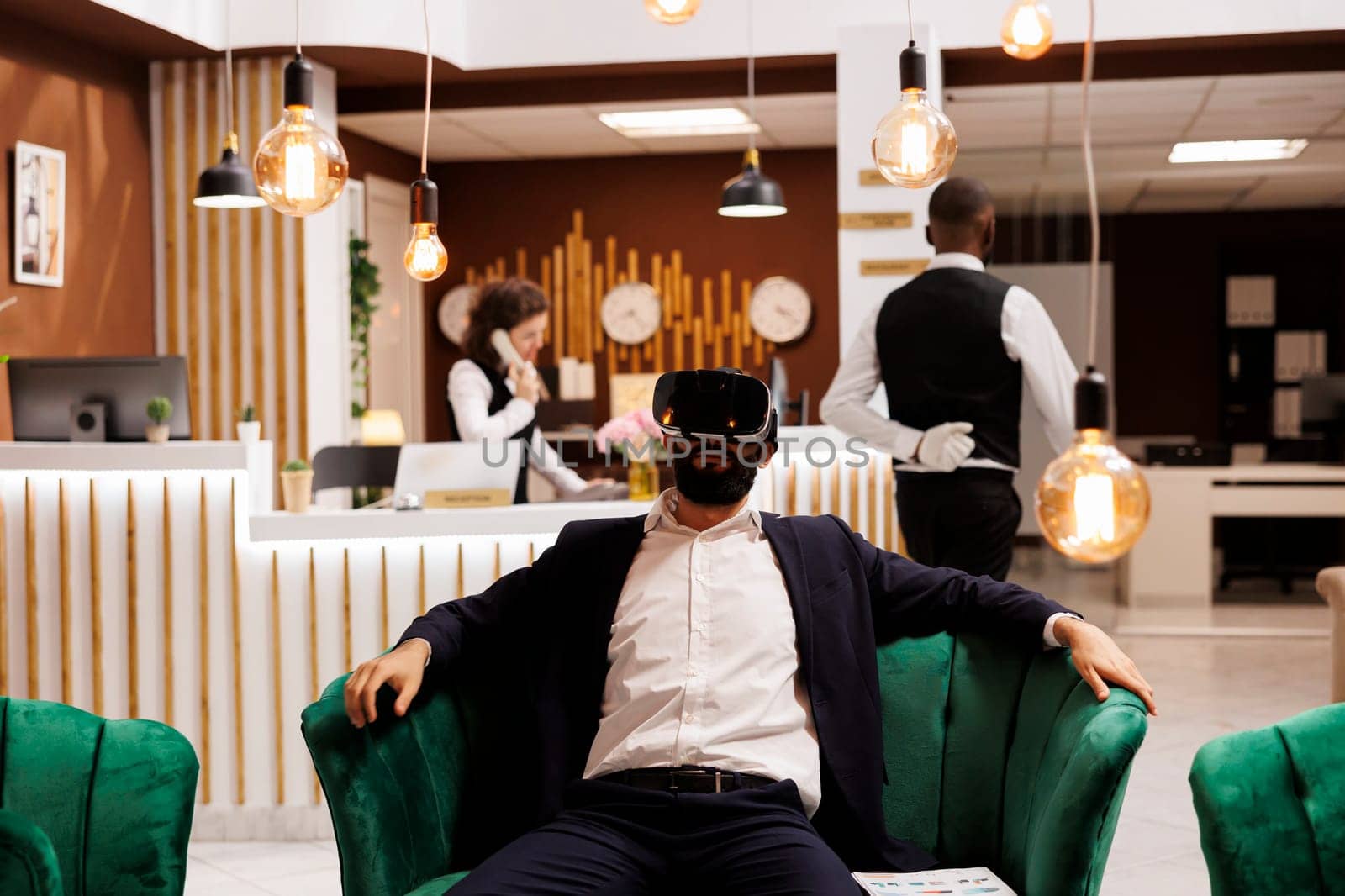 Businessman works with vr headset in hotel lobby, using new 3d interactive vision glasses before doing check in process. Young adult with virtual reality technology on business trip.