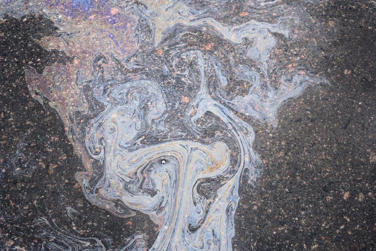 Petroleum fuel spilled on wet asphalt, abstract background by AliaksandrFilimonau