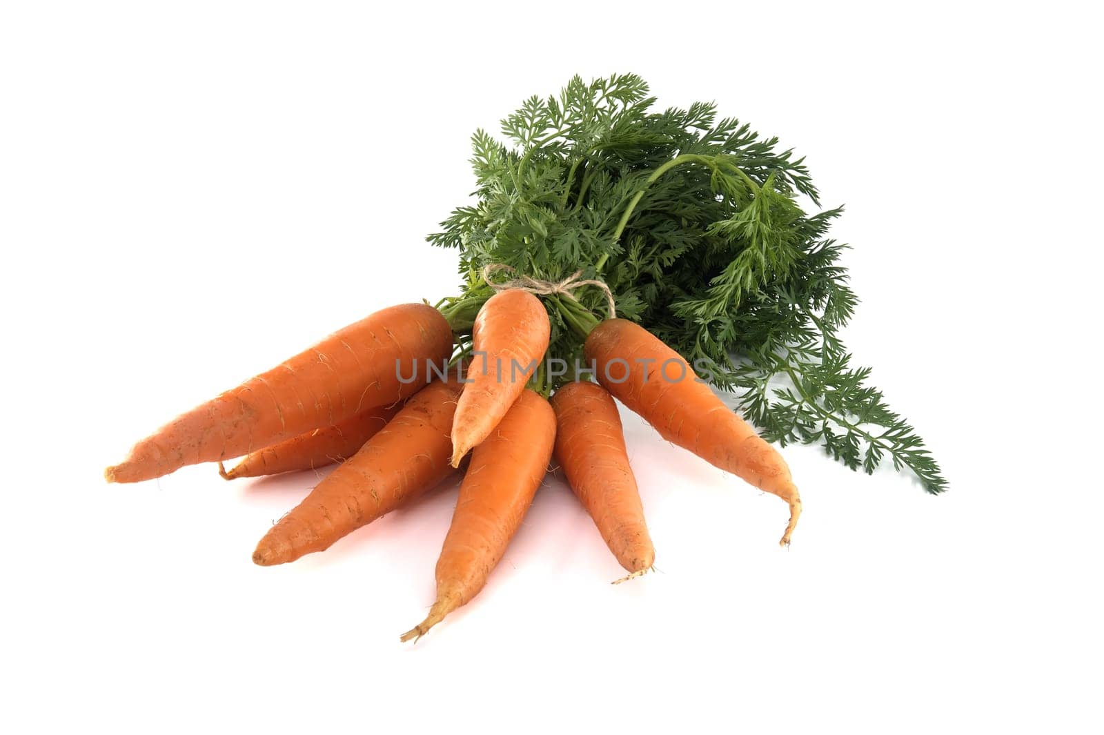Fresh carrots with green leafy tops isolated on white by NetPix