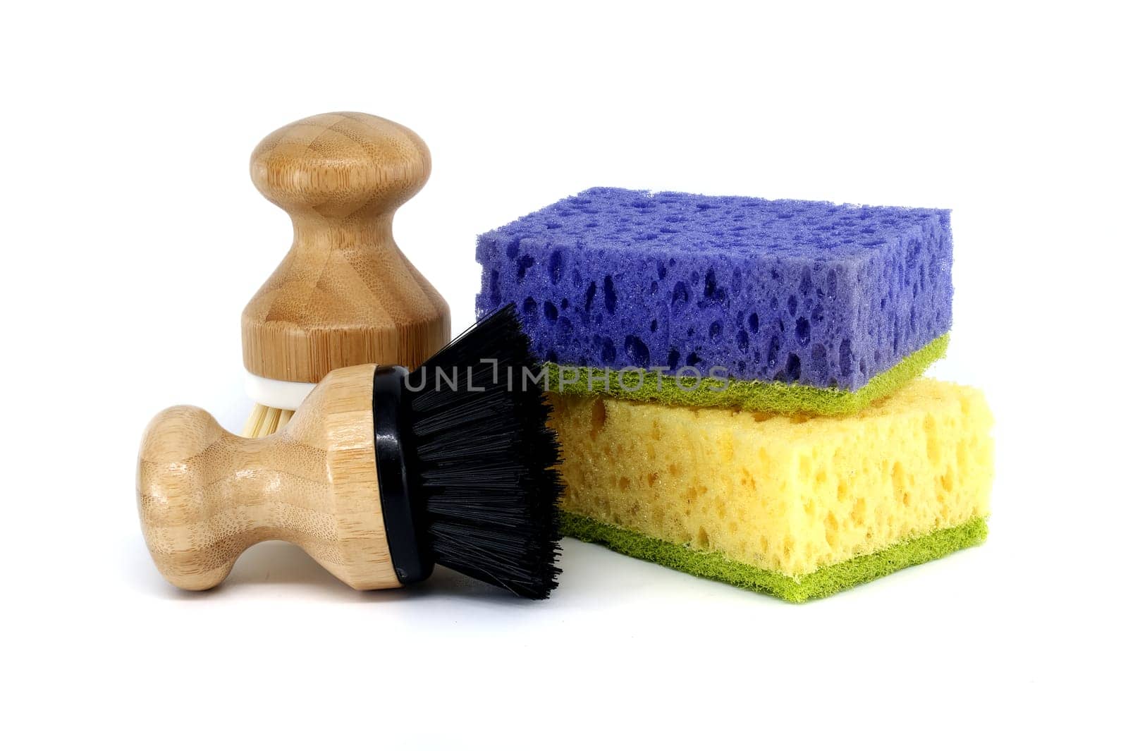 Sponges, each a different color purple, yellow and two brushes with wooden handles isolated on white background, cleaning tools
