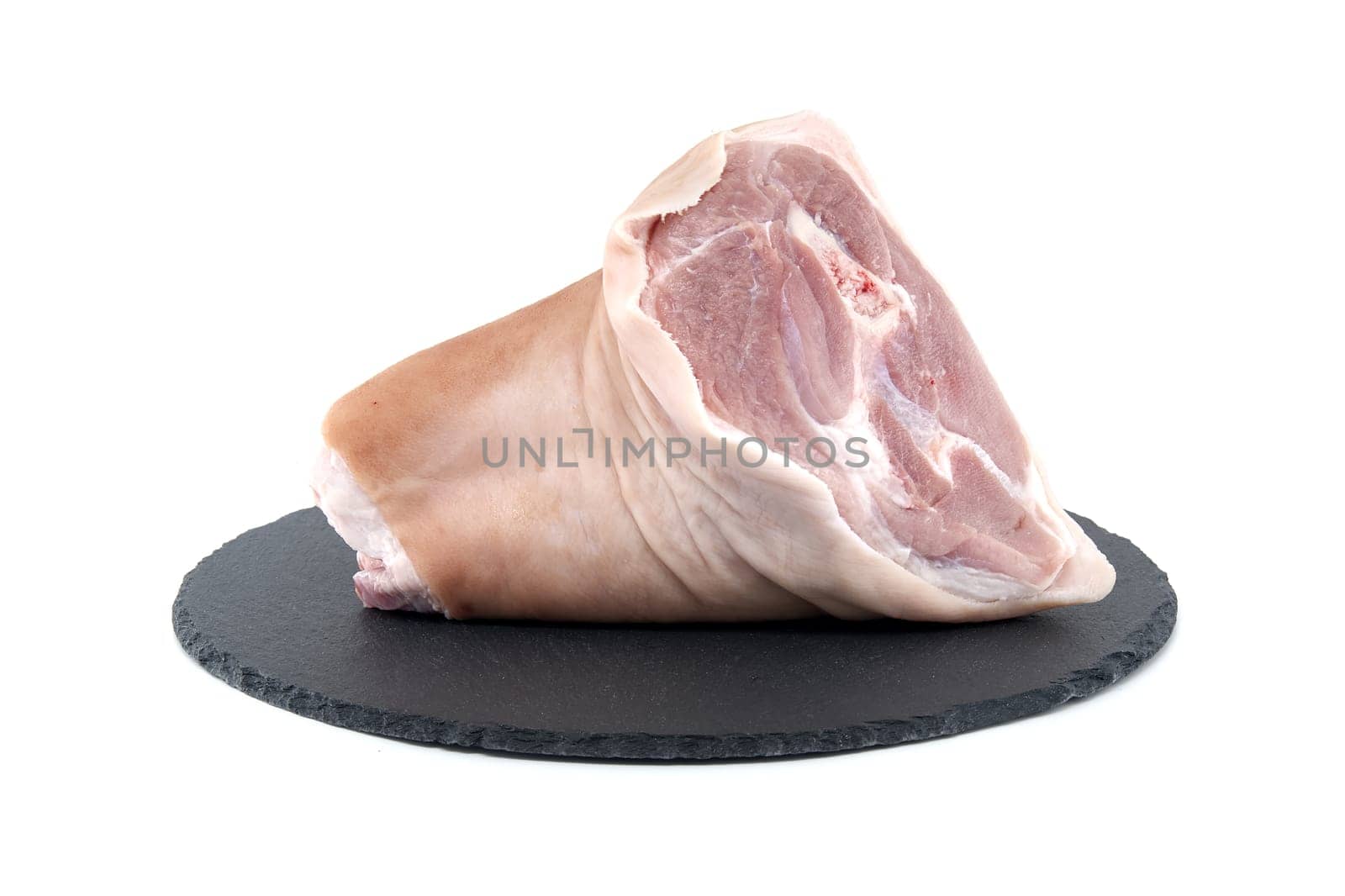 Pork shank on black stone plate over white by NetPix