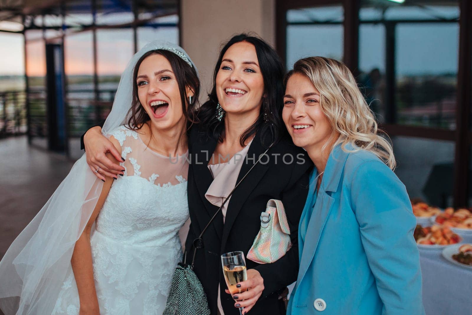 Wedding. bride with guest friends cuddled and laugh drinking champagne Yaremche, Bukovel, Ukraine - January 10, 2022 by malyshph