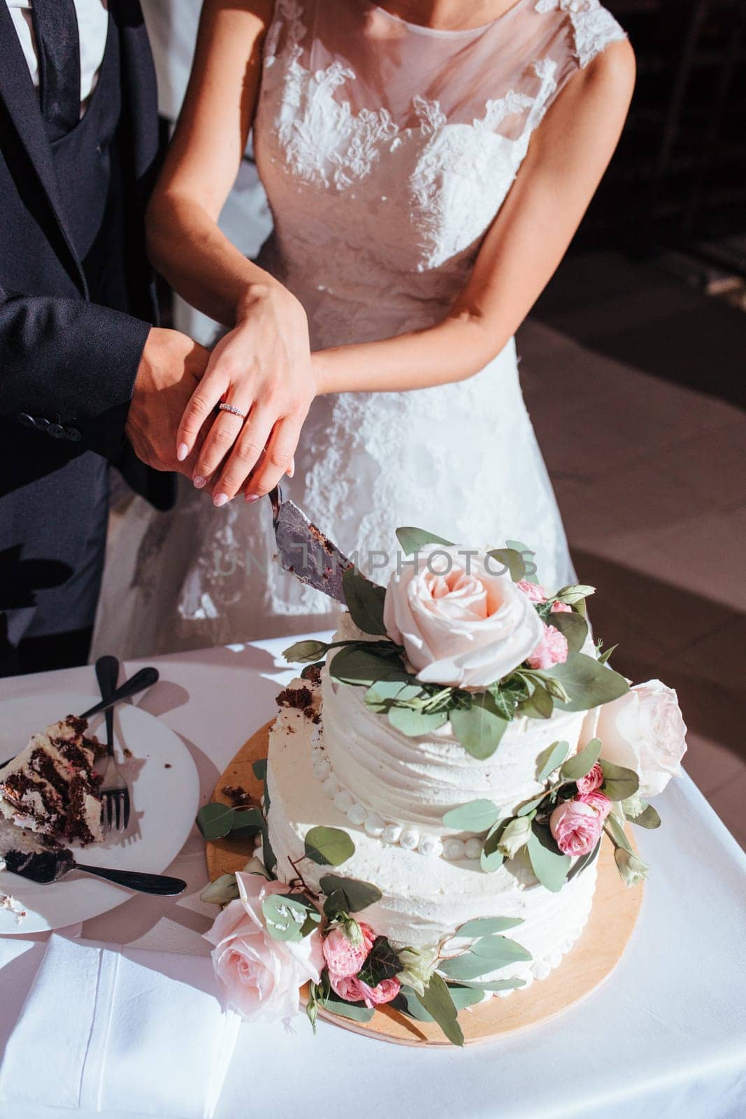 wedding. The bride and groom holding hands cut the wedding cake Yaremche, Bukovel, Ukraine - January 10, 2022 by malyshph
