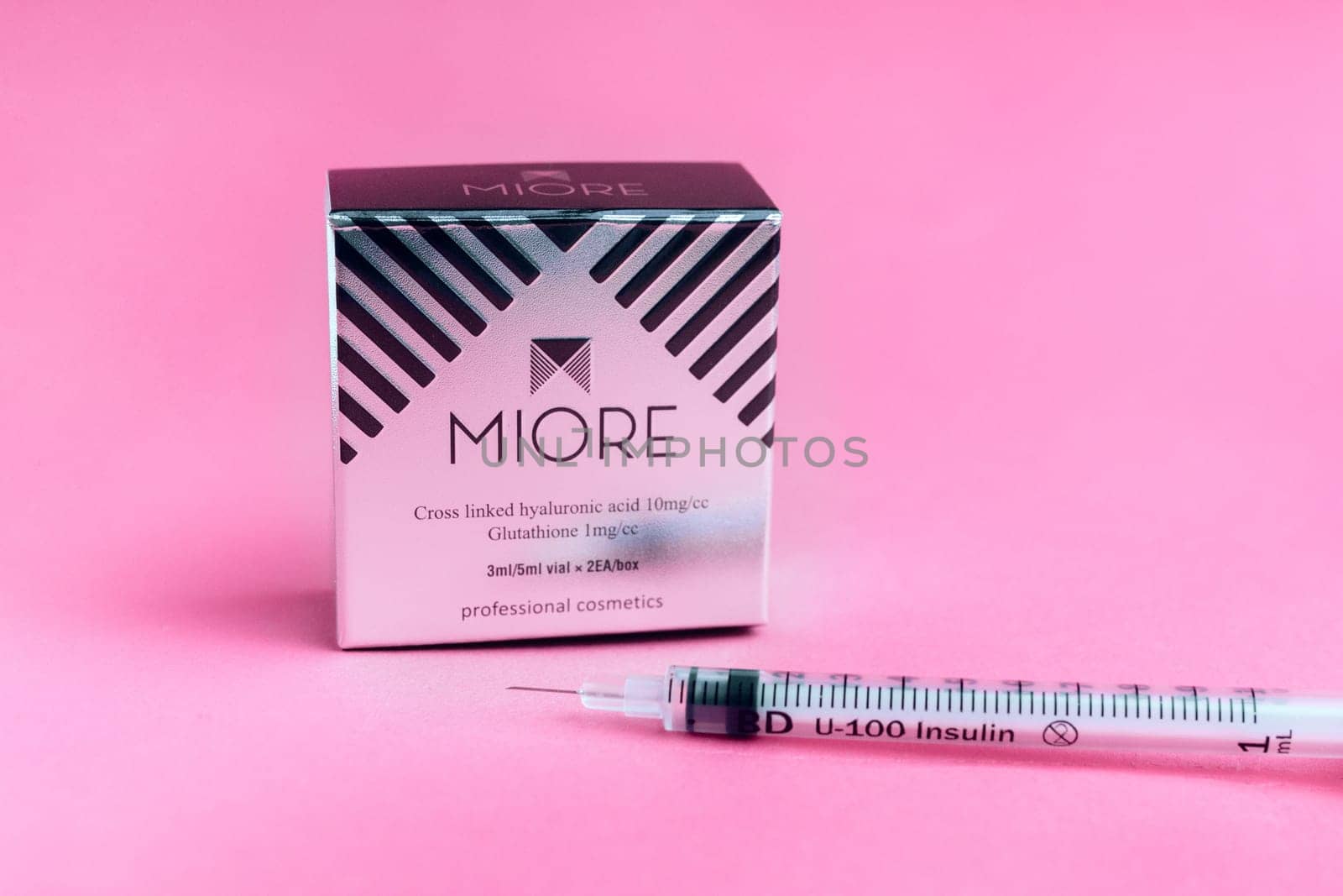 packaging of the drug for biorevitalization of the face miore and a syringe on a pink background. cosmetology and skin careYaremche, Bukovel, Ukraine - January 10, 2022 by malyshph
