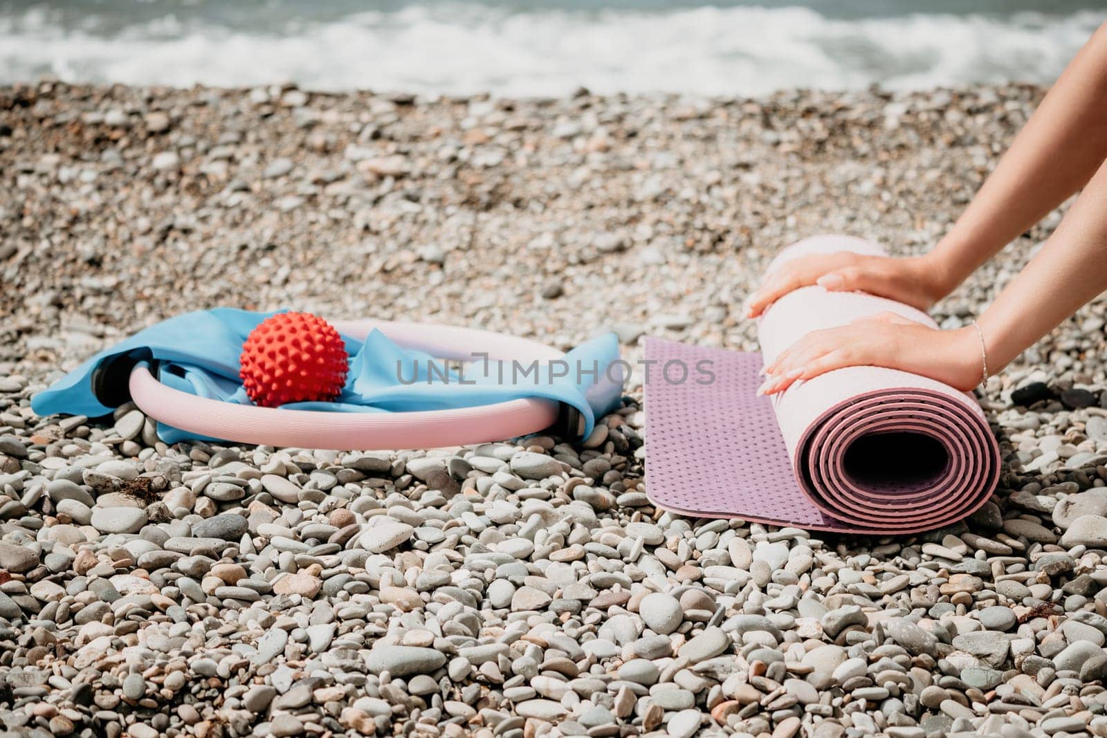 Pilates magic ring and rubber band on yoga mat near sea. Female fitness yoga concept. Healthy lifestyle harmony and meditation. by panophotograph
