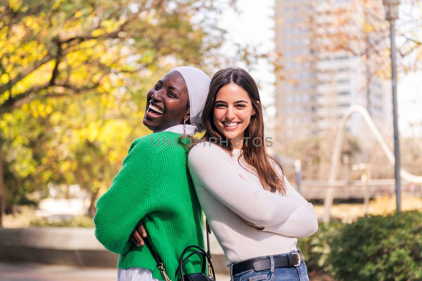 multiracial couple of two funny women smiling looking at camera, concept of friendship and happiness, copy space for text