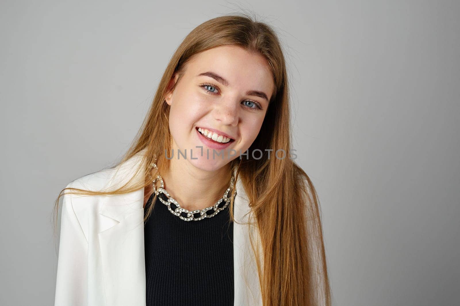 Woman in Black Top and White Jacket Posing in Studio close up