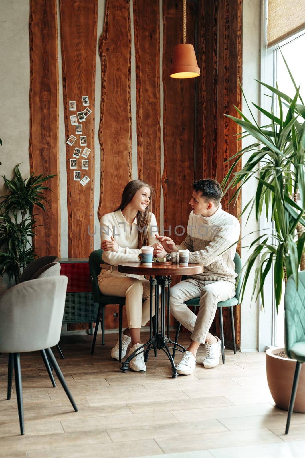Young Couple Enjoying a Coffee Date at a Cozy Cafe During Afternoon Hours by Fabrikasimf