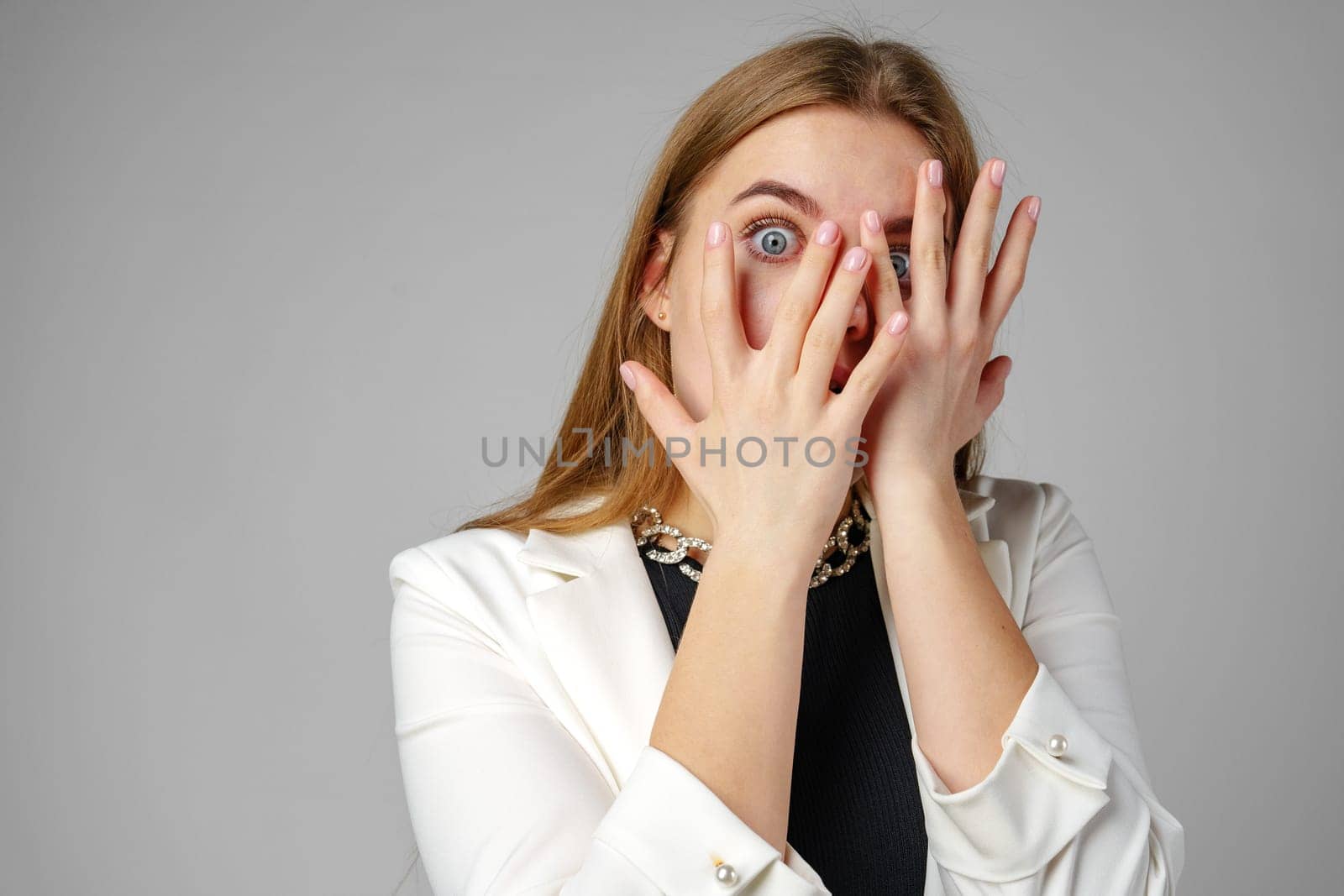 Young Woman Covering Her Eyes With Hands in Studio