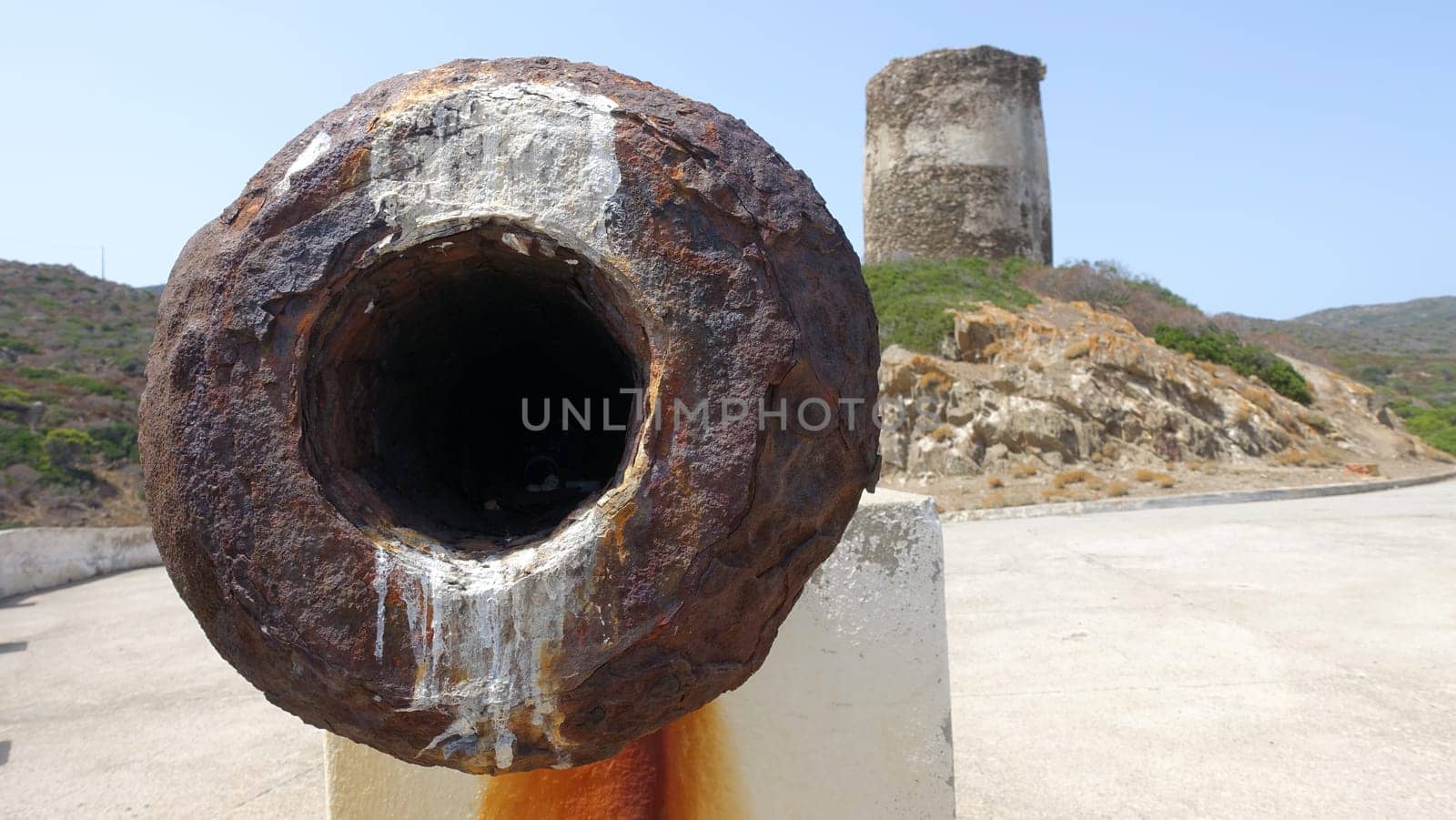 The mouth of an ancient cannon on one of the seaside lookouts of Asinara in Sardinia, Italy. During a summer day.