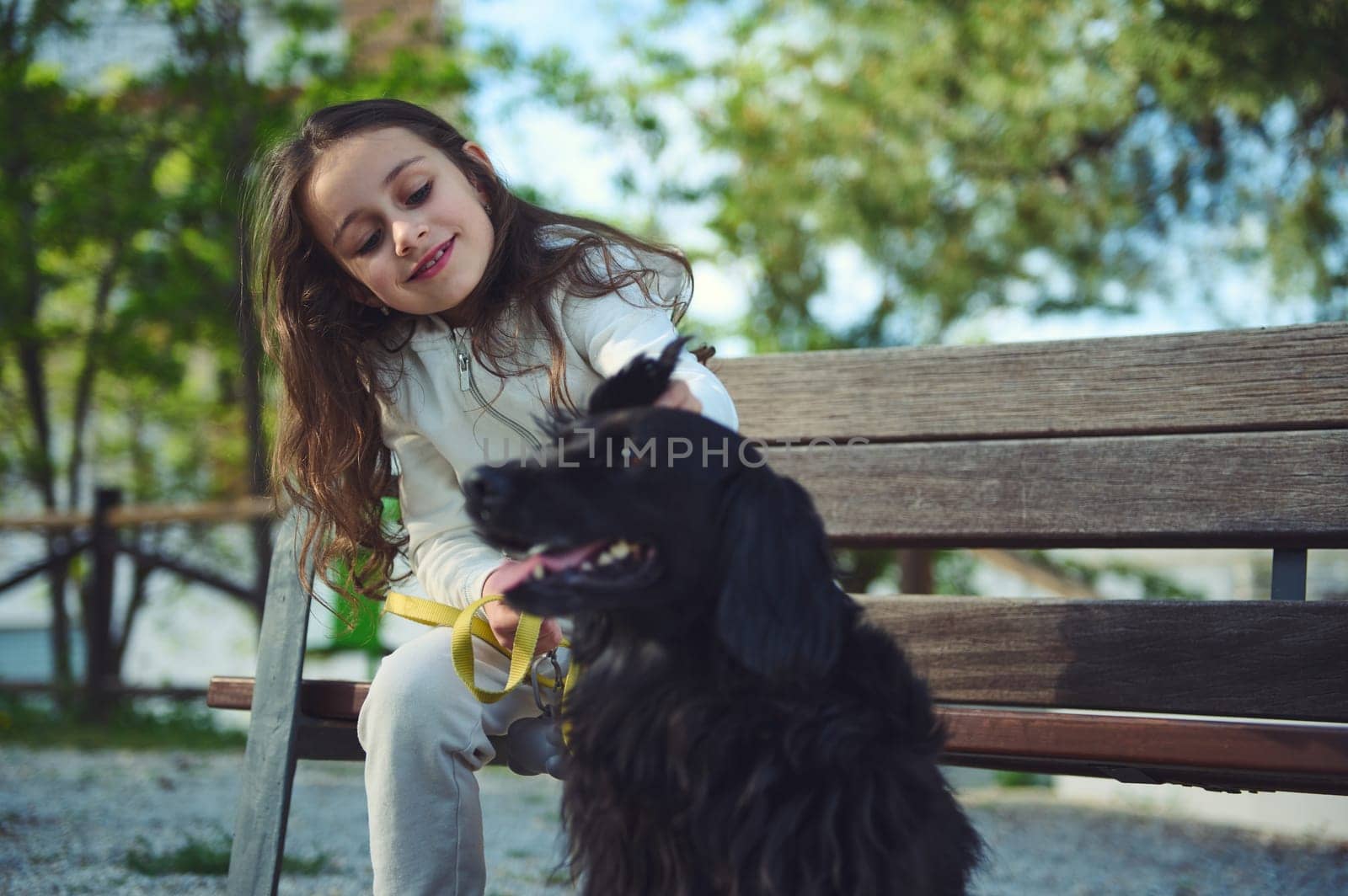 Little girl and her dog during a walk outdoors. People and pets. Lifestyle. The concept of empathy, care and love for animals