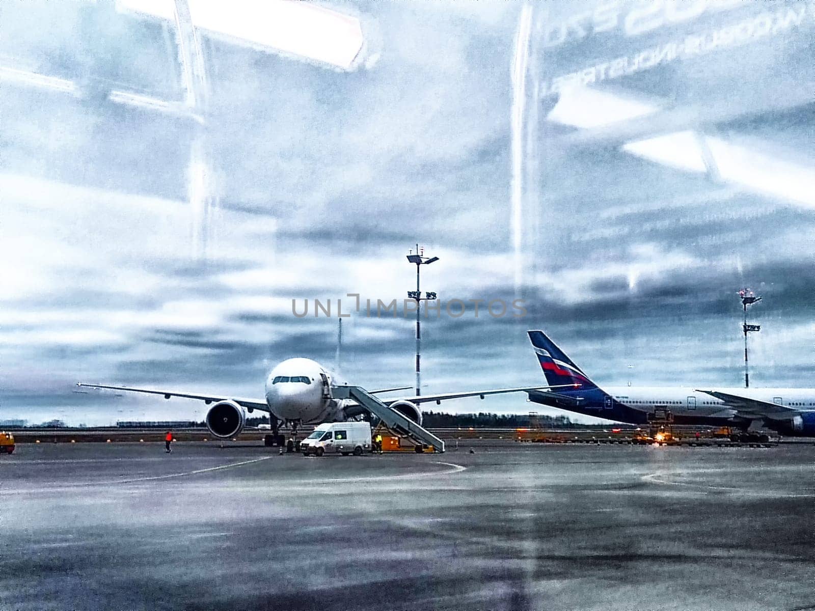 Moscow, Russia - April 04, 2024: planes at the airport, view through the window. Early Morning View of Planes at Airport Through Porthole by keleny