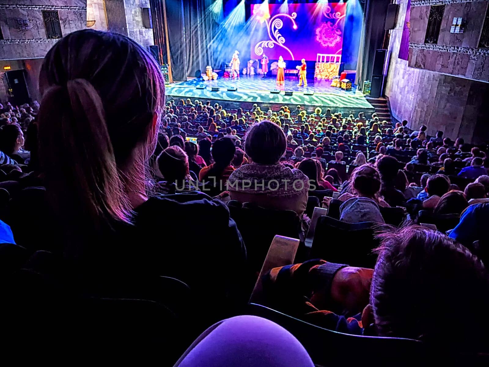 Kirov, Russia - April 14, 2024: A packed auditorium watches an engaging stage performance from a top view. Partial focus