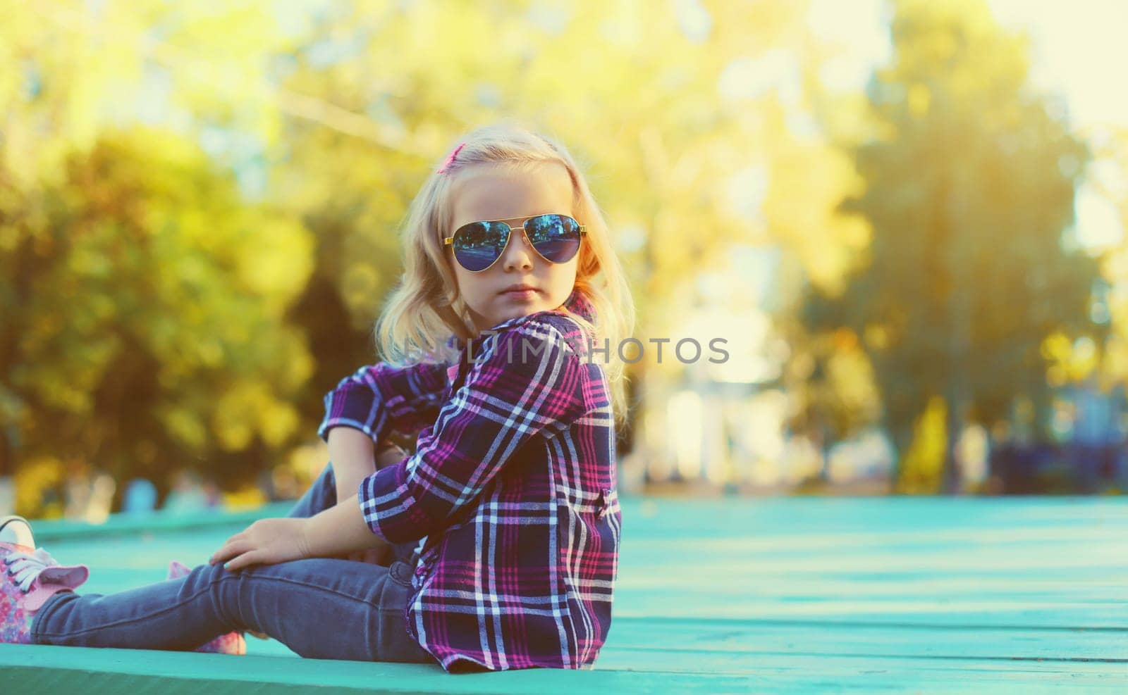 Stylish little girl child in sunglasses in sunny summer park by Rohappy