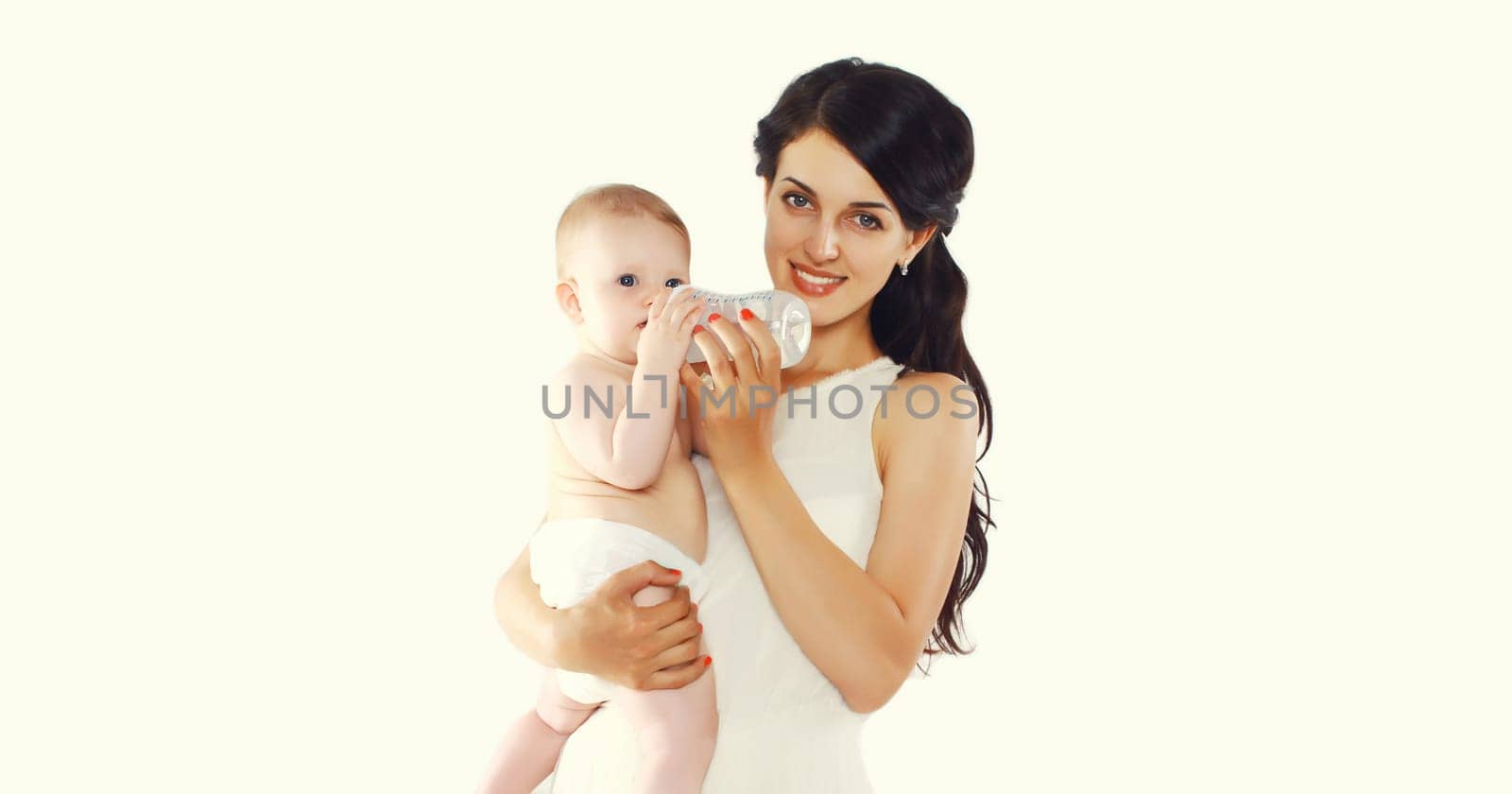 Happy young mother feeding from bottle her baby on white background