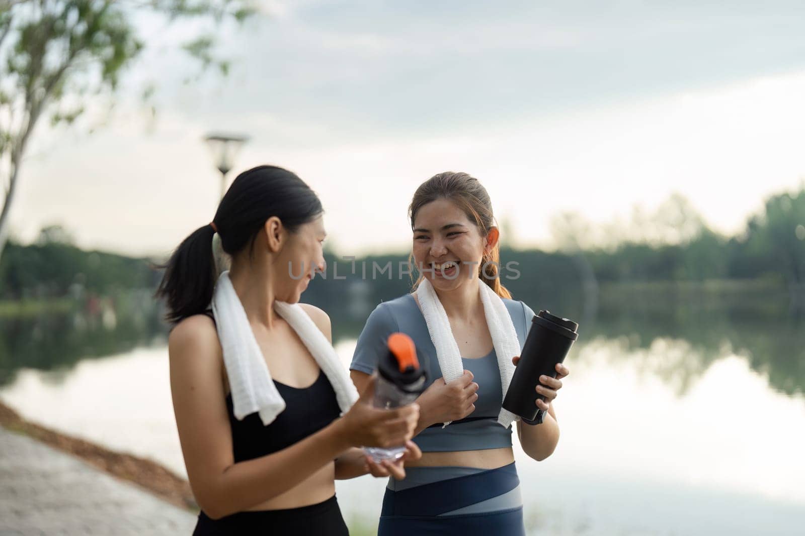 Young women jogger with water bottle in early morning spring sunshine running in town centre. Concept healthy living by itchaznong