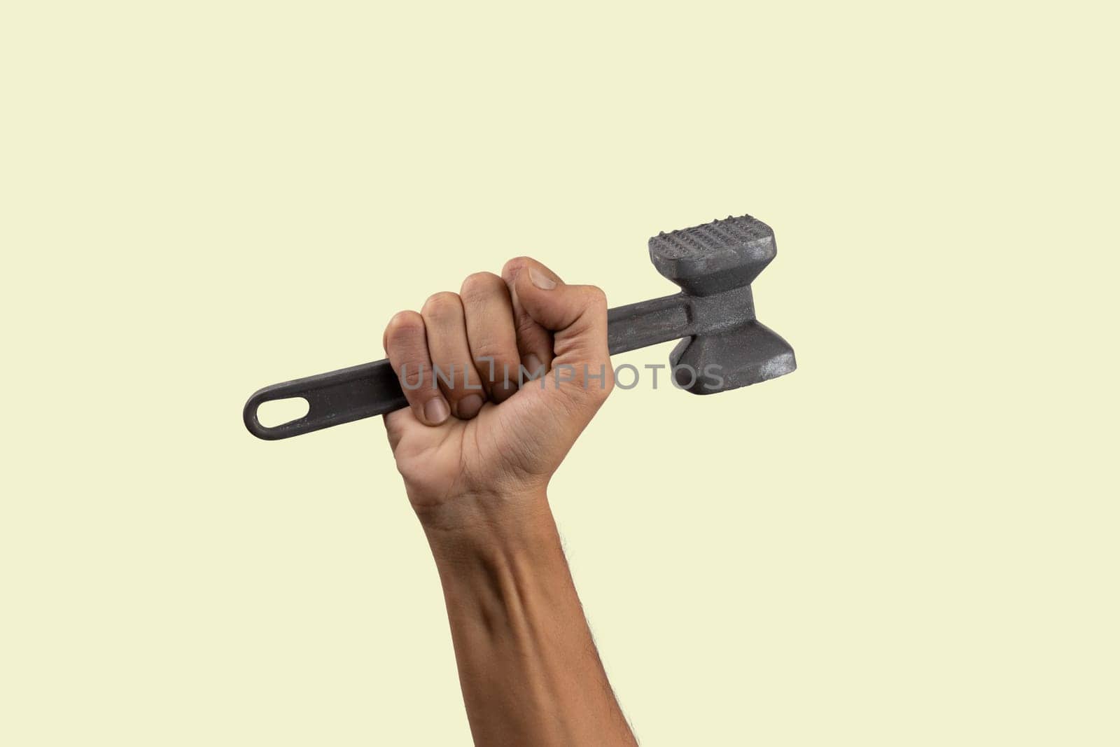 Black male hand holding a kitchen hammer isolated on green background background. High quality photo